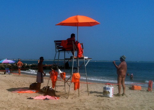 There is a man in a thong. And a hat. Its smart to cover up your head to prevent sun damage.