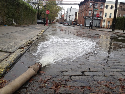 Residents pump water out of their home in Red Hook