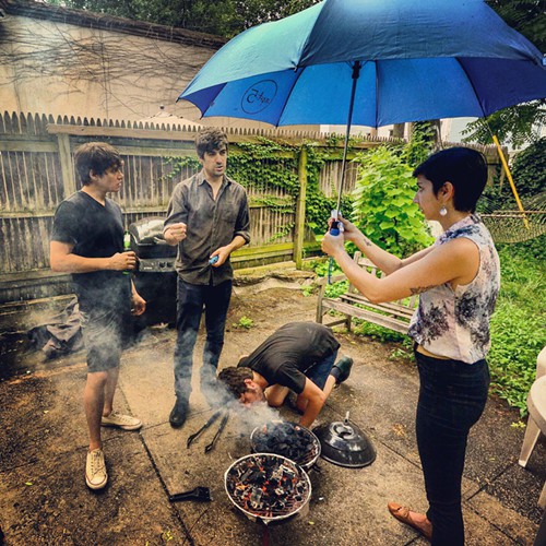 I feel vainly useful holding an umbrella over the grill.