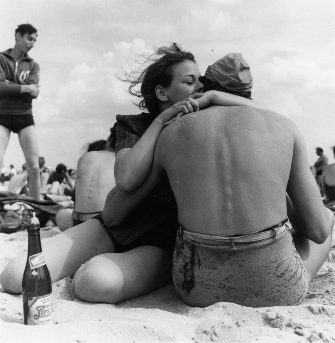 1938: A couple sitting embraces on a crowded beach.  Coney Island, Brooklyn.  New York, New York, 1938. 01/01/1938 Photo by Morris Engel/Getty Images