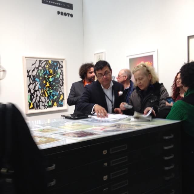 Enrico Gomez busy with some VIP visitors in his booth with Proto Gallery at Art on Paper.