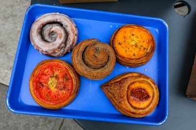 Sausage and peppers focaccia ($8.50), glazed croissant bun ($6), stone fruit custard and heirloom tomato croissants ($7 each), from Radio