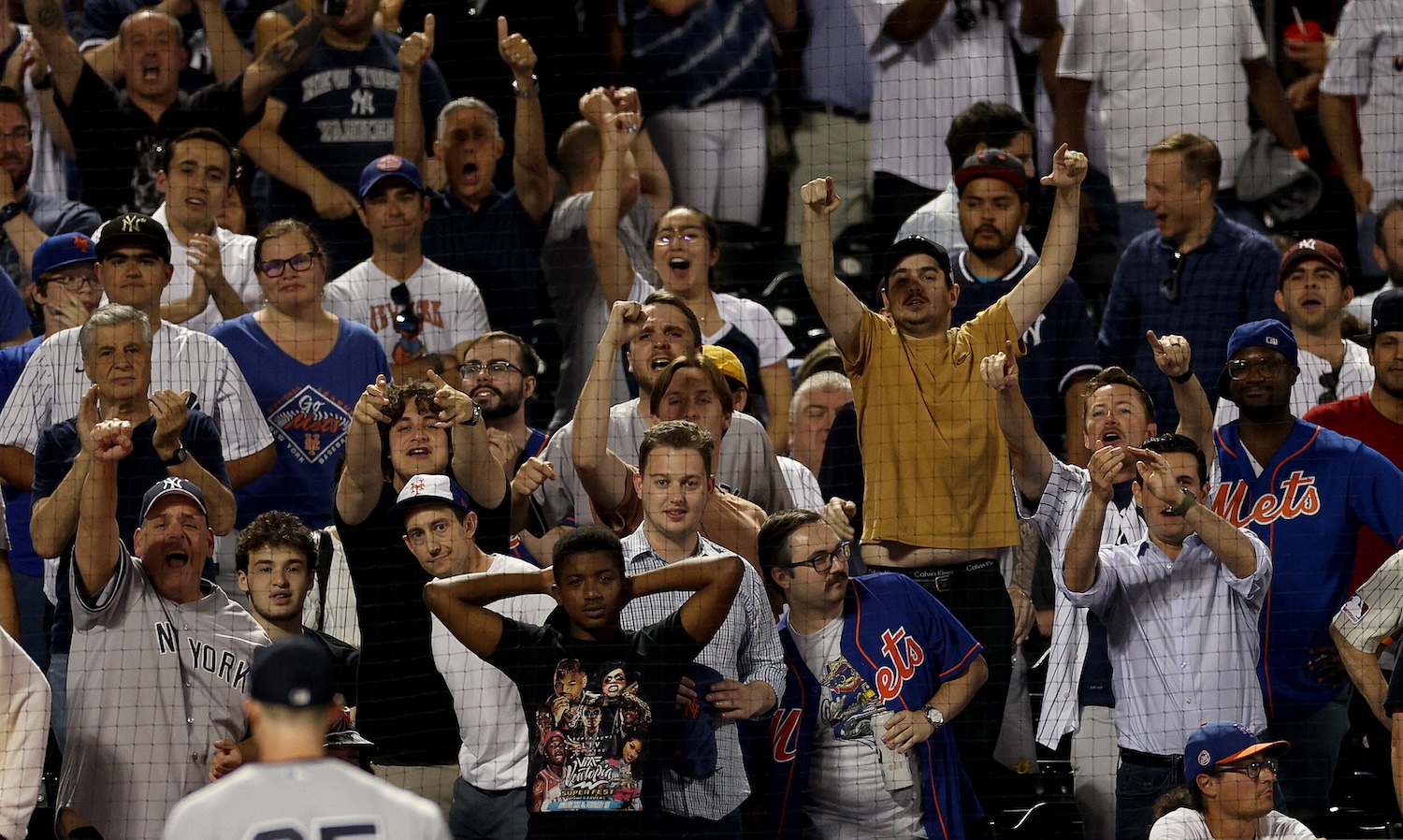 New York Yankees fans celebrate after Clay Holmes #35 of the New York Yankees struck out Starling Marte of the New York Mets with the bases loaded in the eighth inning at Citi Field on June 13, 2023 in the Flushing neighborhood of the Queens borough of New York City.